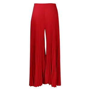 Detailed view of vibrant red pleated high-waisted wide-leg trousers in flowing fabric