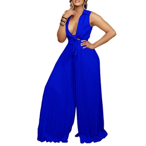 Detail of deep V-neckline with decorative bow tie on a navy blue pleated jumpsuit