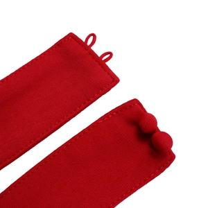 Close-up of red fabric buttons and textured belt loops on a stylish summer outfit