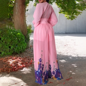 Detail view of pink pleated jumpsuit with blue floral print and elegant long sleeves