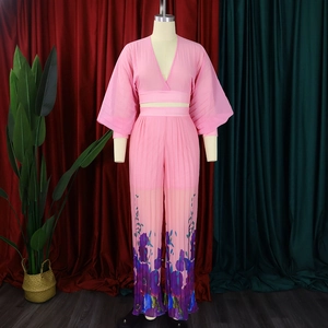 Close-up of pink chiffon set with V-neck pleats and floral wide-leg trousers