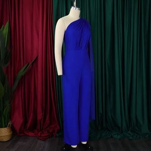 Detail of royal blue one-shoulder jumpsuit featuring a draped cape and wide-leg cut