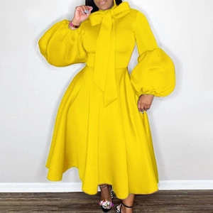 Detailed view of yellow maxi dress featuring statement pussy bow neckline and puff sleeves