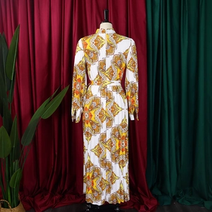 Close-up of pleated long sleeve dress featuring vibrant geometric paisley prints and tie waist