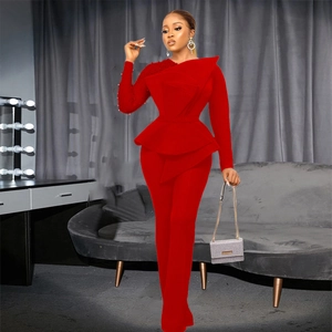 Detail of elegant red mesh jumpsuit featuring beaded sleeve and sculptural ruffles