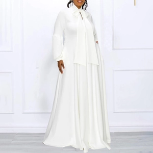 Detail of white maxi dress with large bow tie neckline and elegant puff sleeves
