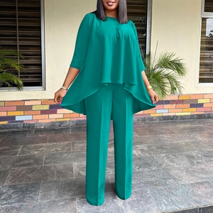 Detail of loose-fit teal two-piece set featuring asymmetrical top and wide-leg trousers