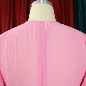 Detail of pink pleated chiffon top with vertical seam and Metamorph woven brand label