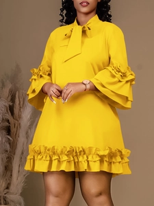 Elegante abito giallo a maniche lunghe con polsini a balze e scollo con fiocco decorativo
