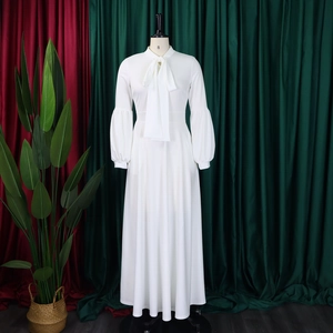 Detail of pussy-bow neckline and elegant lantern sleeves on a white maxi dress
