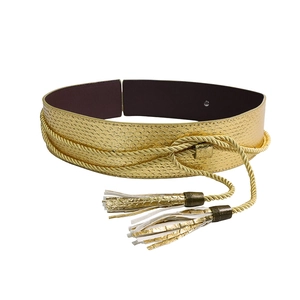 Detail of a golden faux snakeskin belt featuring braided rope and elegant fringe tassels