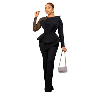 Detail of mesh sleeve with black bead embellishments on a waist-slimming black jumpsuit