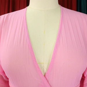 Detail of elegant V-neck pleated chiffon top showing delicate texture and wrap design