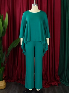 Detail of dark green two-piece set featuring asymmetrical hem top and wide leg pants