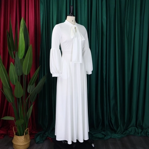 Detail of white maxi dress featuring bow-tie neckline and elegant lantern sleeves on a mannequin
