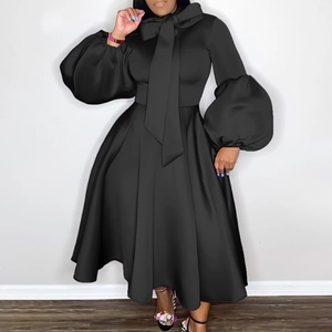 Detail of elegant black plus size dress featuring lantern sleeves and a bow neckline