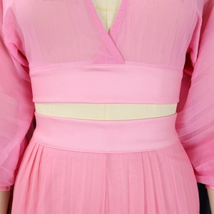 Detail of pink chiffon top featuring deep V-neckline and elegant pleated sleeve texture