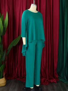 Close-up of dark green two-piece set featuring asymmetrical top and high-waisted trousers