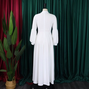 Macro shot of white puff sleeves and high waist detail on the long maxi dress