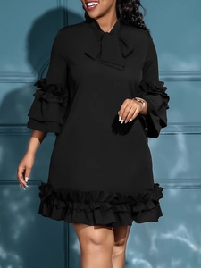Elegante abito nero ampio con maniche a balze multistrato e scollatura con fiocco