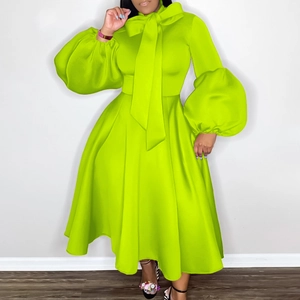 Detailed view of the lantern sleeves and oversized bow neckline on neon green party dress