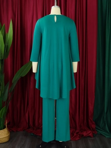 Rear view of emerald green irregular hem top and wide leg pants set on a mannequin