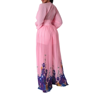 Detail of pink pleated jumpsuit featuring intricate floral print and matching waist belt