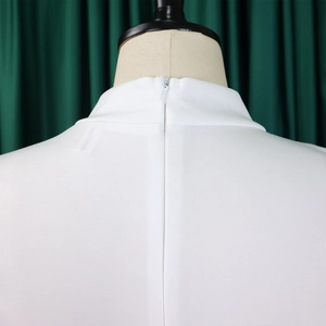 Detail of high neck white maxi dress showing invisible back zipper and premium fabric