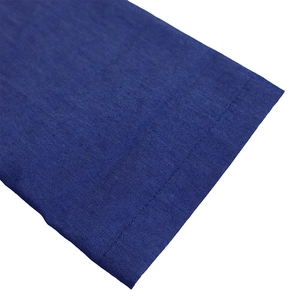 Détail du tissu denim bleu foncé avec texture de tissage visible et coutures soignées