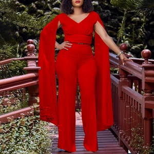 Détail d'un ensemble rouge deux pièces avec manches cape et pantalon large taille haute
