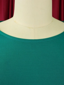 Close-up of crew neck design and fine mesh knitted texture on green two-piece outfit