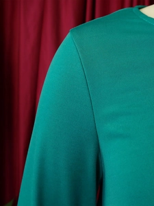 Detailed view of teal round neck top showing high-quality knitted fabric and shoulder seams
