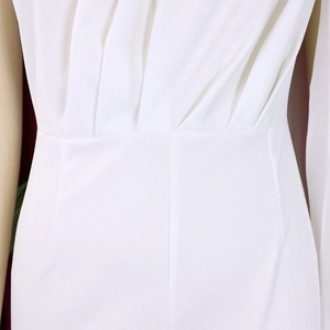 Detail of white one-shoulder jumpsuit with pleated waist and smooth tailored fabric