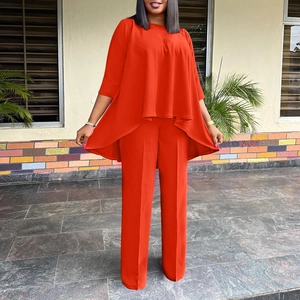 Detail of red two-piece wide-leg pants set showing premium draping fabric on model
