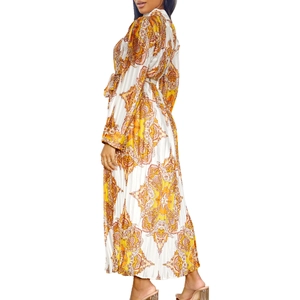 Detail of bohemian paisley print on a pleated long sleeve maxi dress with waist tie