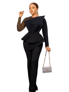 Elegant black jumpsuit with structured ruffles, sheer mesh sleeve, and beaded details