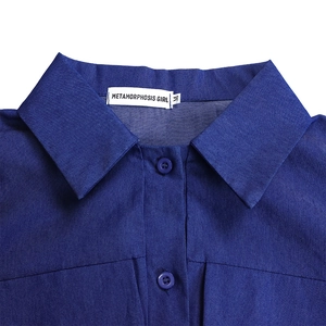 Gros plan du col de chemise avec coutures en denim et étiquette de marque sur robe longue