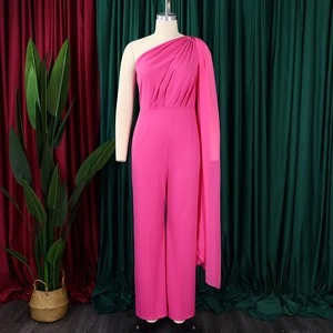 Detail of pink one-shoulder jumpsuit featuring a long cape drape and wide-leg cut