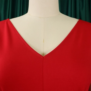 Gros plan du décolleté en V profond et de la texture du tissu sur un haut rouge tendance