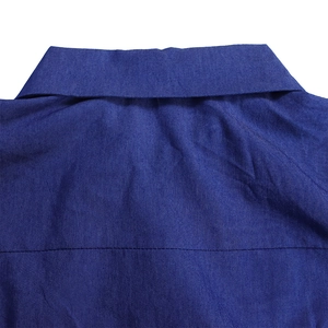 Détail d'une robe en jean bleue montrant le col classique et les coutures au dos