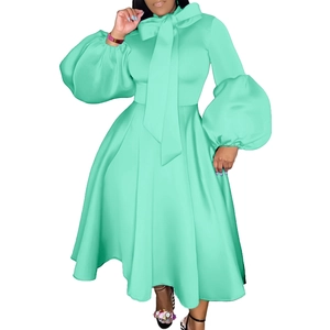 Detail of mint green party dress featuring oversized bow tie and dramatic puff sleeves