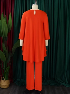 Rear view detail of bright orange two-piece set featuring back button and loose fit