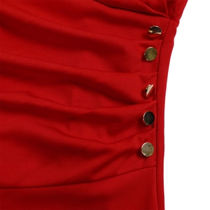 Close-up of red pleated dress fabric with five decorative gold buttons along the side seam