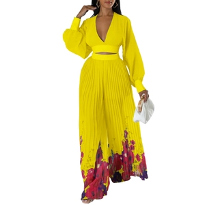 Detail of yellow two-piece vacation set featuring a V-neck crop top and floral wide-leg pants