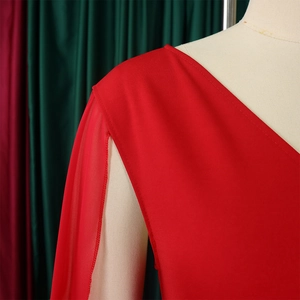 Détail du haut rouge à col en V avec manches en mousseline et texture en maille douce