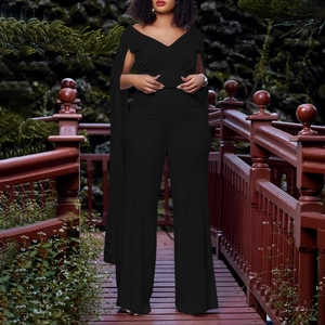 Détail d'une combinaison noire à col en V profond avec manches cape et pantalon large