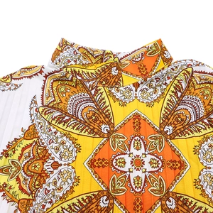Detail of colorful paisley print dress with pleated fabric and small stand collar