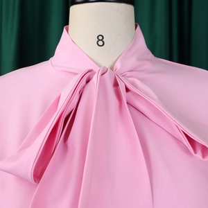 Detailed view of large pink bow tie neckline on a stylish bell sleeve A-line dress