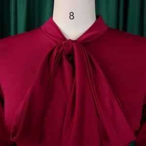 Detail of high waist dark red dress featuring a stand collar and bow tie neckline design