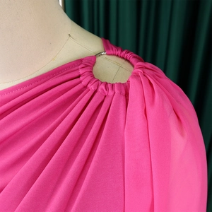 Detail of rose pink jumpsuit with shoulder metal ring and elegant pleating texture